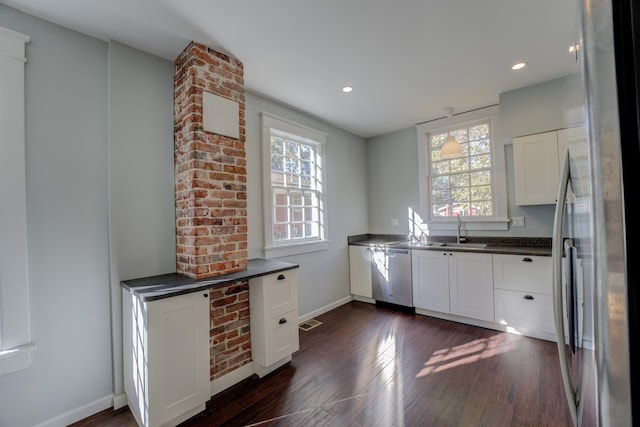 kitchen with plenty of natural light, white cabinets, dark hardwood / wood-style floors, and appliances with stainless steel finishes