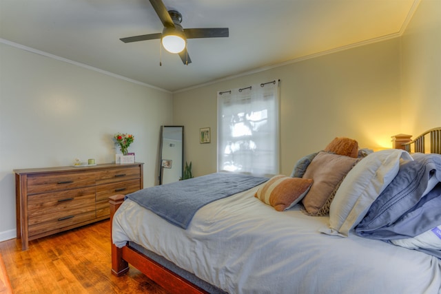 bedroom with hardwood / wood-style flooring, ceiling fan, and crown molding