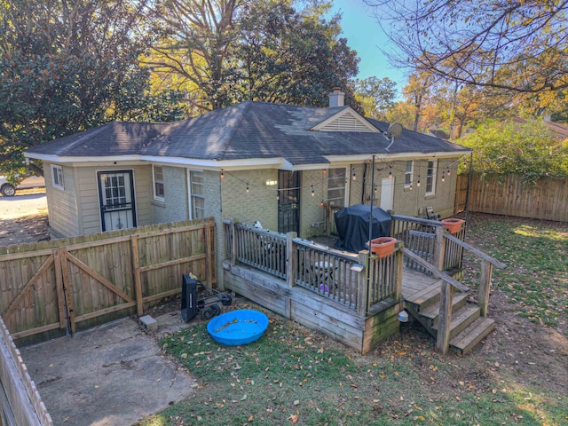 back of house featuring a deck and a yard