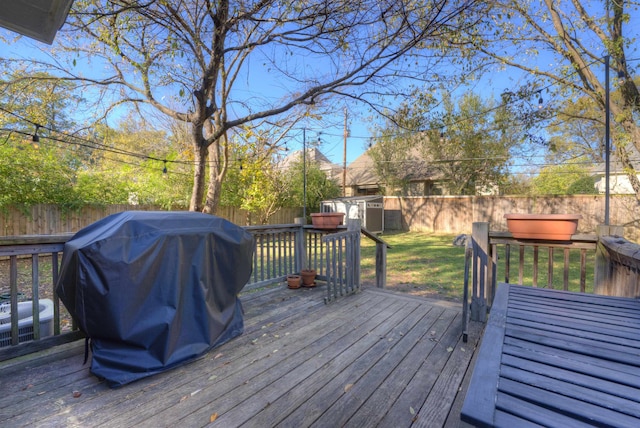 wooden deck with area for grilling and a shed