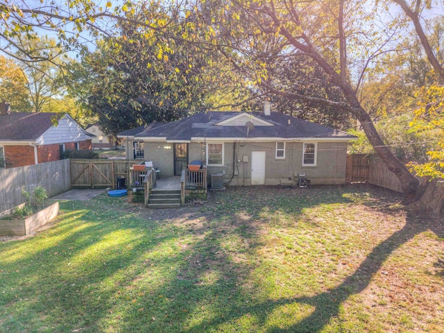 rear view of property featuring a lawn, cooling unit, and a deck