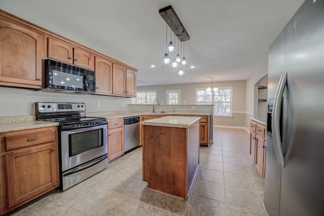 kitchen with sink, a center island, hanging light fixtures, a chandelier, and appliances with stainless steel finishes