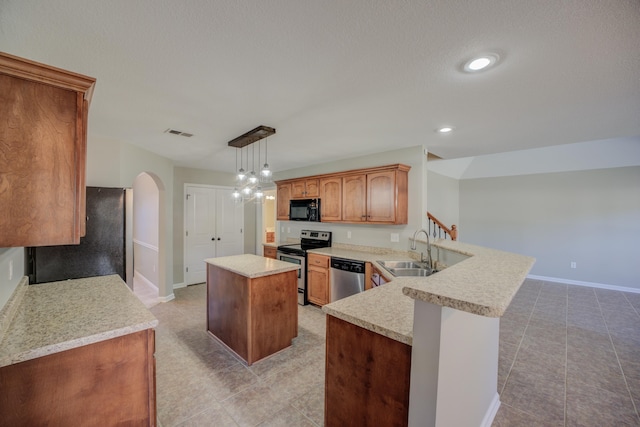 kitchen featuring sink, stainless steel appliances, kitchen peninsula, decorative light fixtures, and a kitchen island