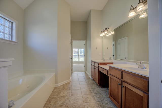 bathroom featuring tile patterned flooring, vanity, a tub, and a healthy amount of sunlight