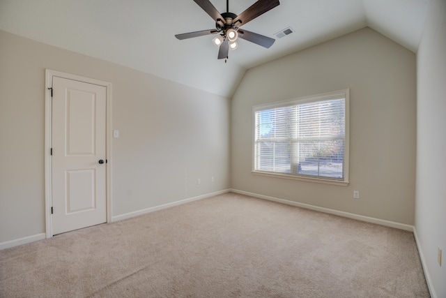 empty room with light carpet, vaulted ceiling, and ceiling fan