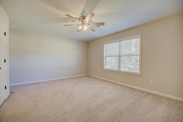 spare room featuring ceiling fan and light colored carpet