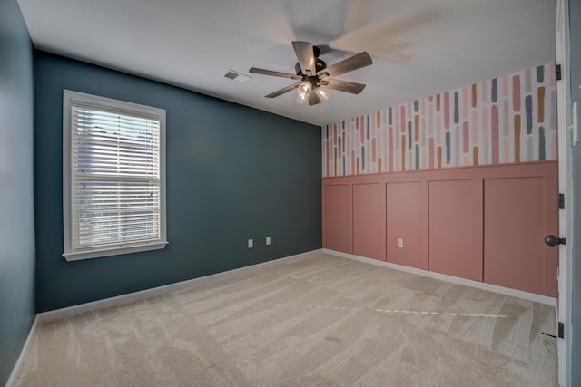 carpeted empty room featuring ceiling fan