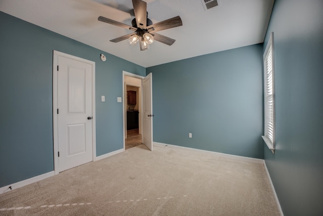 unfurnished bedroom with light carpet, multiple windows, and ceiling fan