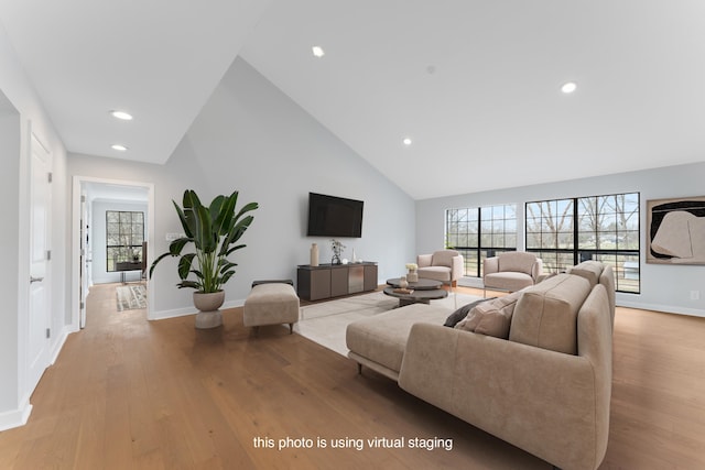 living room featuring high vaulted ceiling and light wood-type flooring