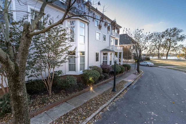 property exterior at dusk featuring a balcony