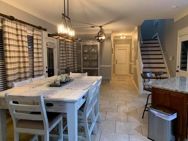 dining area featuring an inviting chandelier, ornamental molding, and light tile patterned flooring