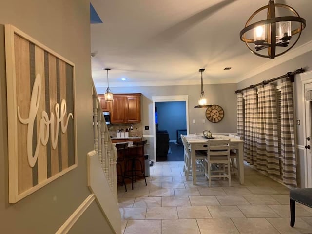 tiled dining area with crown molding and an inviting chandelier