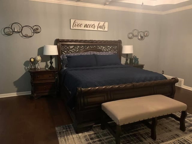 bedroom featuring wood-type flooring, a raised ceiling, and crown molding