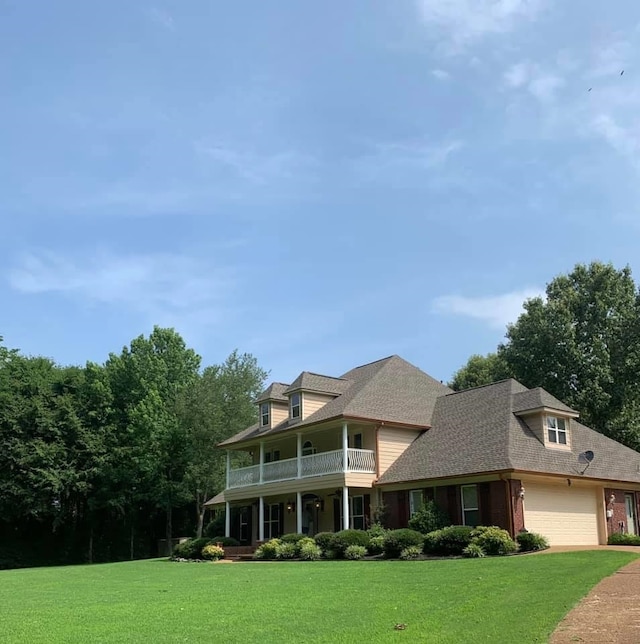 view of front of property with a front lawn, a porch, and a garage