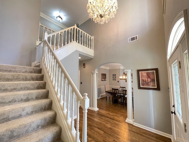 entryway with a high ceiling, dark hardwood / wood-style floors, crown molding, and a healthy amount of sunlight