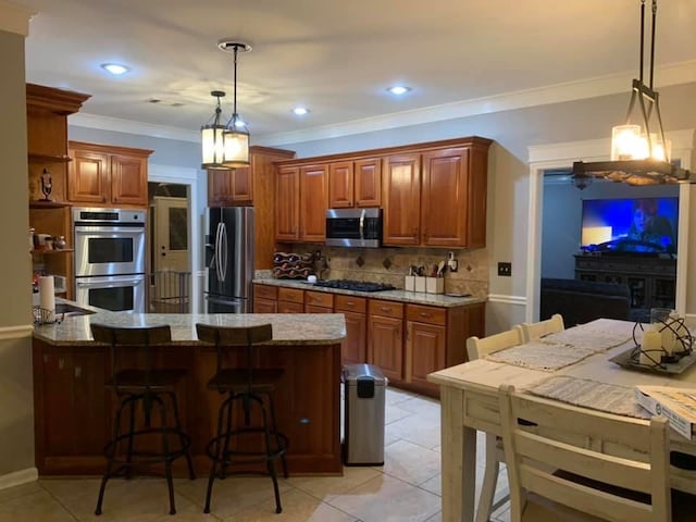 kitchen with backsplash, a breakfast bar area, ornamental molding, light stone counters, and stainless steel appliances