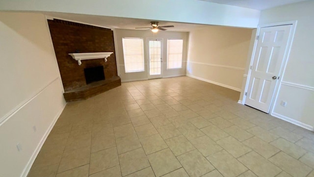 unfurnished living room with ceiling fan, light tile patterned floors, french doors, and a brick fireplace