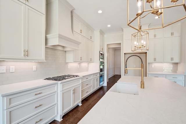 kitchen featuring pendant lighting, custom exhaust hood, dark wood-type flooring, appliances with stainless steel finishes, and white cabinetry