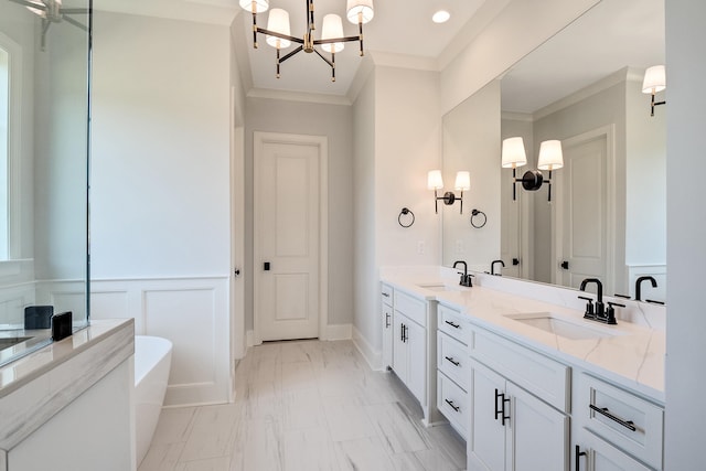 bathroom with vanity, ornamental molding, a tub to relax in, and a chandelier