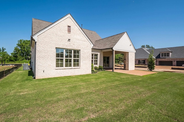 rear view of property featuring a lawn, cooling unit, and a patio