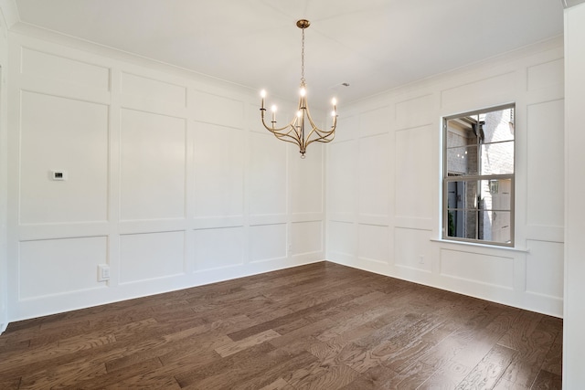 empty room featuring dark wood-type flooring and a notable chandelier