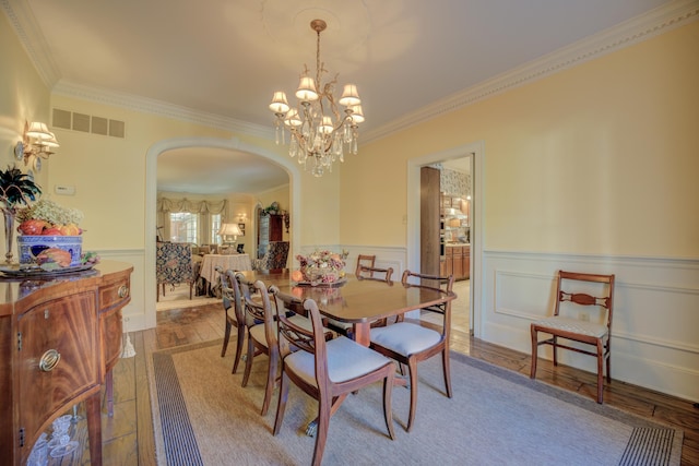 dining space featuring a chandelier, hardwood / wood-style floors, and ornamental molding