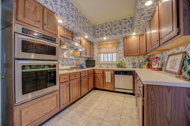 kitchen with light tile patterned flooring, sink, crown molding, and appliances with stainless steel finishes