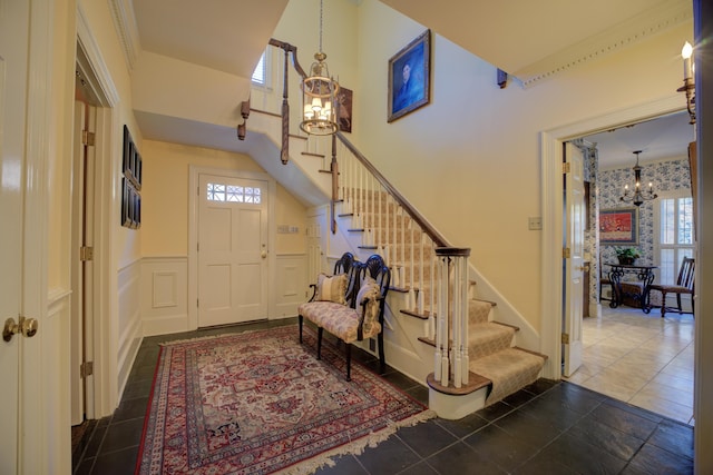 tiled foyer with a chandelier