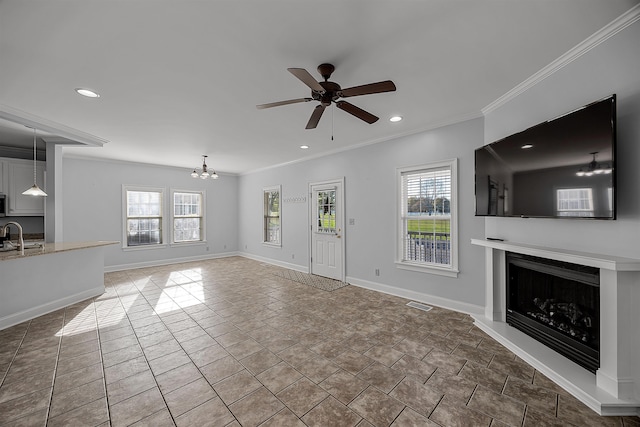 6 Laura Ln, Iuka, MS 38852 - unfurnished living room featuring ceiling fan with notable chandelier, a healthy amount of sunlight, and crown molding