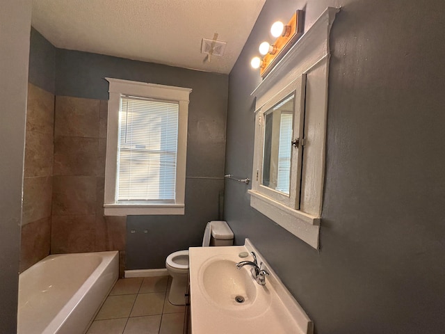 bathroom with tile patterned floors, vanity, toilet, and a textured ceiling