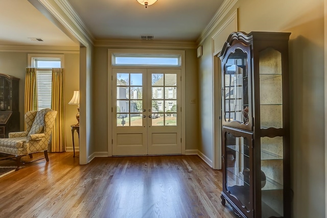 doorway to outside featuring hardwood / wood-style floors, crown molding, and french doors