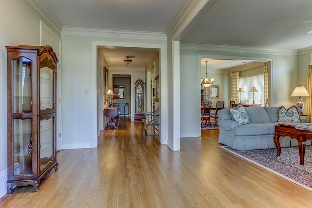 living room featuring light hardwood / wood-style flooring, a notable chandelier, and ornamental molding