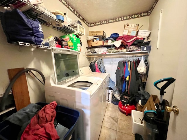 laundry area with washing machine and clothes dryer and light tile patterned floors