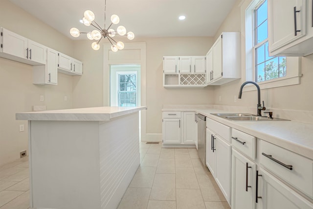 kitchen with pendant lighting, white cabinetry, a notable chandelier, and sink