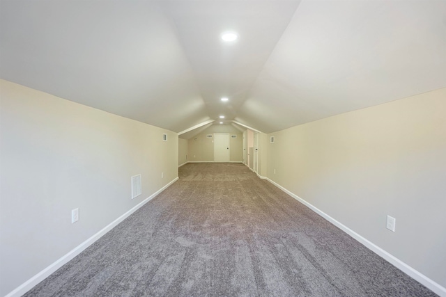 additional living space with carpet flooring and vaulted ceiling