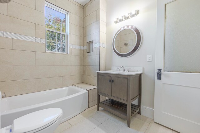 full bathroom featuring tile patterned floors, tiled shower / bath, vanity, and toilet