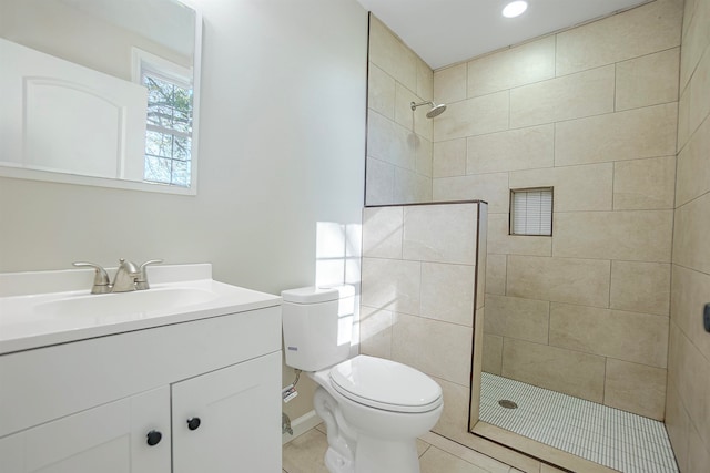 bathroom featuring tiled shower, tile patterned flooring, vanity, and toilet