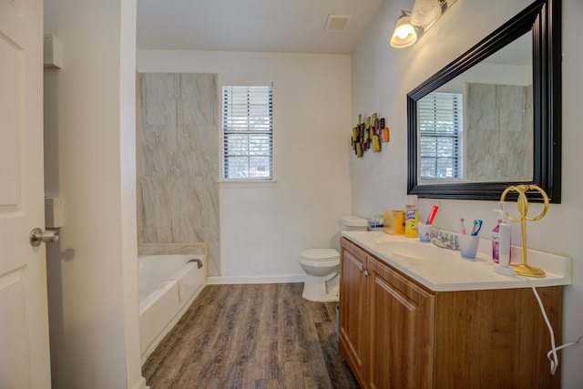 bathroom featuring hardwood / wood-style flooring, vanity, toilet, and a bathing tub