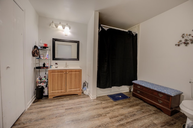 bathroom with hardwood / wood-style floors, vanity, toilet, and a shower with curtain