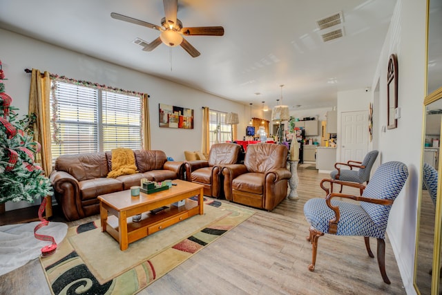 living room featuring light hardwood / wood-style floors and ceiling fan