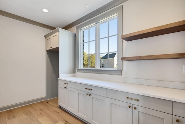 interior space featuring gray cabinets, light stone countertops, and light wood-type flooring