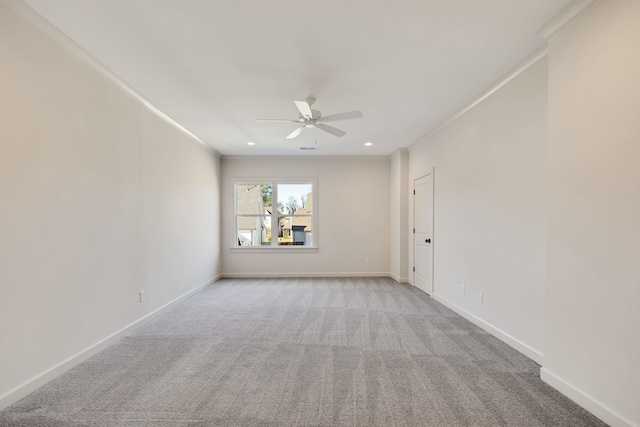 carpeted spare room featuring ceiling fan and ornamental molding