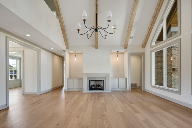 unfurnished living room with a chandelier, beam ceiling, high vaulted ceiling, and light hardwood / wood-style flooring