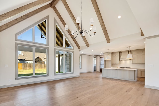 unfurnished living room featuring beam ceiling, high vaulted ceiling, light hardwood / wood-style flooring, and a notable chandelier