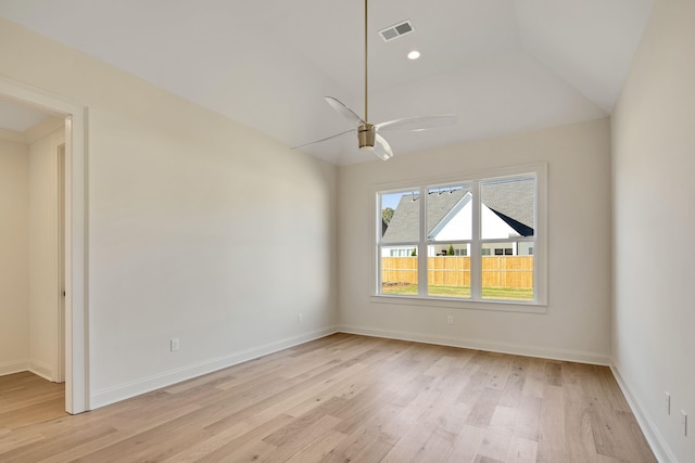 spare room with ceiling fan, light wood-type flooring, and vaulted ceiling