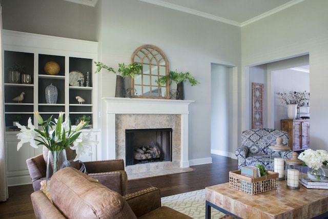 living room with a premium fireplace, ornamental molding, and dark hardwood / wood-style flooring