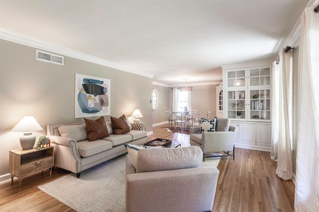 living room featuring ornamental molding and light wood-type flooring