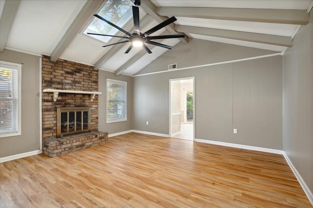 unfurnished living room with lofted ceiling with skylight, a fireplace, ceiling fan, and light hardwood / wood-style floors