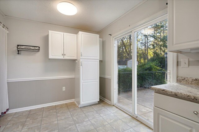 interior space with a textured ceiling and ornamental molding