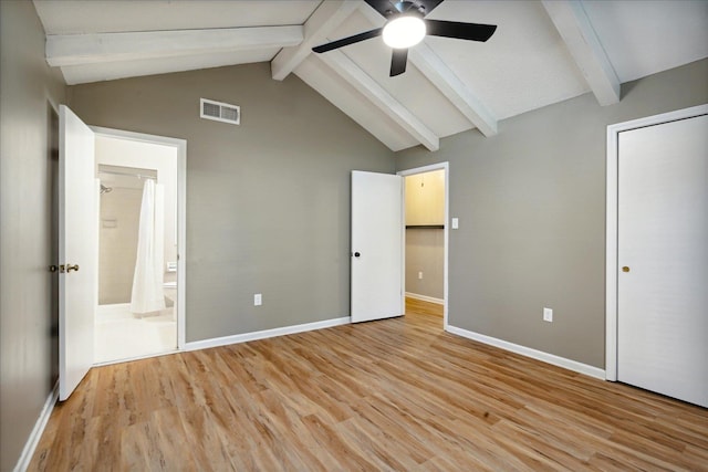 unfurnished bedroom with lofted ceiling with beams, light hardwood / wood-style floors, ceiling fan, and connected bathroom